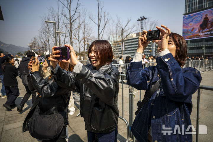 [서울=뉴시스] 정병혁 기자 = 방탄소년단(BTS)의 서울 광화문광장 컴백 공연을 앞둔 17일 서울 종로구 세종문화회관 계단을 찾은 일본인 팬들이 방탄소년단 랩핑 앞에서 사진을 찍고 있다. 2026.03.17. jhope@newsis.com