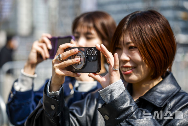 [서울=뉴시스] 정병혁 기자 = 방탄소년단(BTS)의 서울 광화문광장 컴백 공연을 앞둔 17일 서울 종로구 세종문화회관 계단을 앞에서 일본인 팬들이 방탄소년단 랩핑 사진을 찍고 있다. 2026.03.17. jhope@newsis.com