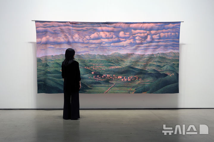 [서울=뉴시스] 박진희 기자 = 갤러리현대는 이우성 작가의 개인전 대형 걸개그림 ‘잘 지내고 계신가요? 저는 여기에서 잘 지내고 있습니다.’(2021). ‘리얼 디엠지 프로젝트(Real DMZ Project)’ 커미션으로 제작된 작품으로, 김포 애기봉 전망대에서 바라본 북한 개풍군 해물 선전마을 풍경. 2026.03.17. pak7130@newsis.com