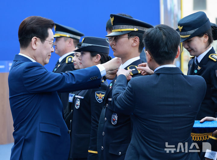 [아산=뉴시스] 고범준 기자 = 이재명 대통령이 17일 충남 아산시 경찰대학에서 열린 2026년 신임 경찰 경위·경감 임용식에서 이태환 경위에게 계급장을 달아주고 있다. 2026.03.17. bjko@newsis.com