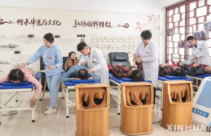 [지난=신화/뉴시스] 지난달 16일 중국 산둥성 룽청시의 한 지역 보건소에서 전통 중의학 시립병원 의료진이 노인들에게 물리치료 서비스를 제공하고 있다. 2026.04.28