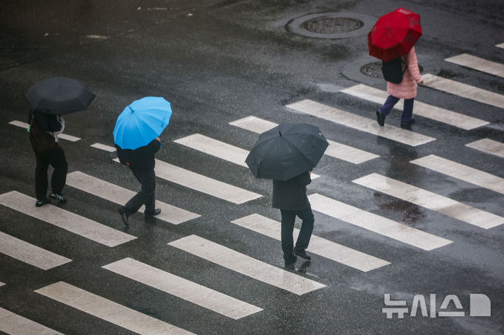 [서울=뉴시스] 정병혁 기자 = 18일 서울 중구 을지로입구역 인근 횡단보도에서 우산을 쓴 시민들이 이동하고 있다. 2026.03.18. jhope@newsis.com