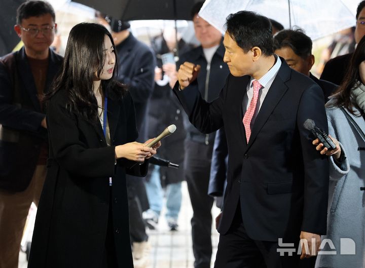 [서울=뉴시스] 조성우 기자 = '명태균 여론조사비 대납' 의혹으로 기소된 오세훈 서울시장이 18일 오전 서울 서초구 서울중앙지방법원에서 열린 정치자금법 위반 혐의 관련 2차 공판에 출석하며 지지자들을 향해 주먹을 쥐어 보이고 있다. (공동취재) 2026.03.18. photo@newsis.com