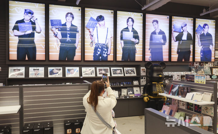 [서울=뉴시스] 김근수 기자 =  방탄소년단(BTS) 컴백 라이브: ARIRANG의 광화문 공연을 사흘 앞둔 18일 오후 서울 중구 명동거리에 위치한 케이메카 명동본점에서 한 외국인이 사진을 찍고 있다. 2026.03.18. ks@newsis.com