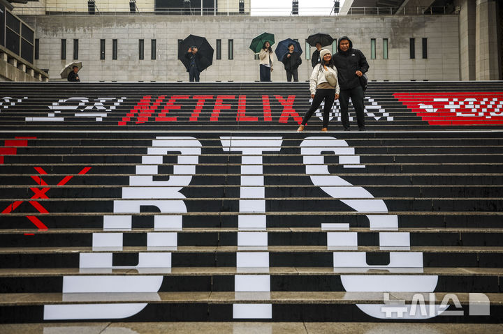 [서울=뉴시스] 정병혁 기자 =  방탄소년단(BTS)의 서울 광화문광장 컴백 공연을 앞둔 18일 서울 종로구 세종문화회관 계단을 찾은 외국인 팬들이 BTS 랩핑 앞에서 사진을 찍고 있다. 2026.03.18. jhope@newsis.com