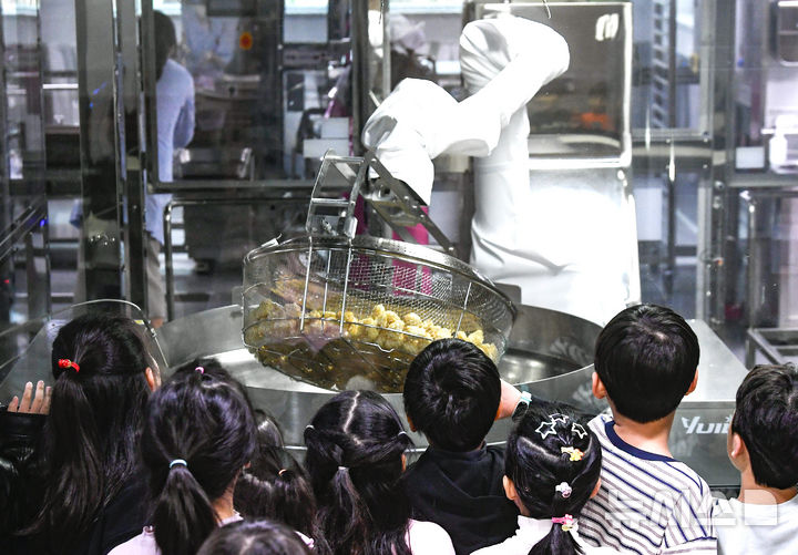 [수원=뉴시스] 김종택 기자 =지난달 18일 경기 수원시 한 학교급식 튀김 지원실에서 1학년 학생들이 음식을 조리하는 급식 로봇을 살펴보고 있다. 해당 사진은 기사와 직접 관련이 없습니다. (공동취재) 2026.03.18. photo@newsis.com