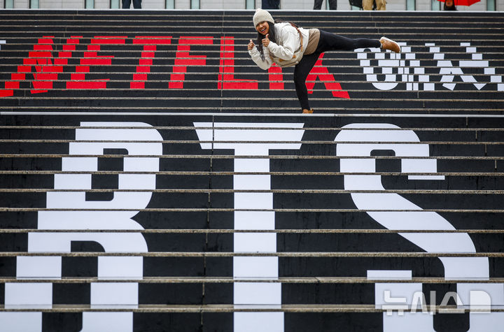 [서울=뉴시스] 정병혁 기자 =  방탄소년단(BTS)의 서울 광화문광장 컴백 공연을 앞둔 18일 서울 종로구 세종문화회관 계단을 찾은 외국인 팬들이 BTS 랩핑 앞에서 사진을 찍고 있다. 2026.03.18. jhope@newsis.com