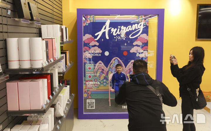 [서울=뉴시스] 김근수 기자 = 방탄소년단(BTS) 컴백 라이브: ARIRANG의 광화문 공연을 사흘 앞둔 18일 오후 서울 중구 명동거리의 한 K-POP 굿즈 판매점에서 외국인들이 포토부스에서 사진을 찍고 있다. 2026.03.18. ks@newsis.com