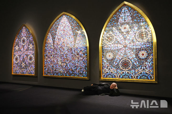 [서울=뉴시스] 박진희 기자 = 영국 시각미술가 데이미언 허스트(Damien Hirst)가 18일 서울 종로구 국립현대미술관에서 아시아 최초 대규모 개인전 ‘진실은 없어 그러나 모든 것은 가능하지’ 기자간담회 갖고 작품 '신의 무한한 권능과 영광을 묵상하며' 앞에서 포즈를 취하고 있다. 2026.03.18. pak7130@newsis.com