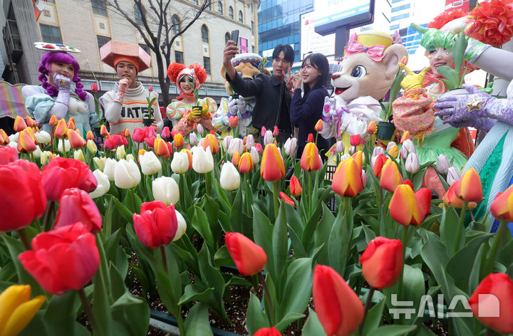 [서울=뉴시스] 홍효식 기자 = 18일 서울 중구 명동 일대 한 거리에서 열린 '도심에서 미리 만나는 에버랜드 튤립축제'에서 에버랜드 공연 연기자와 모델들이 포즈를 취하고 있다.에버랜드는 오는 20일부터 '에버랜드 튤립축제'를 개최하며 튤립, 수선화, 무스카리 등 100여종 약 120만송이 형형색색 봄꽃을 선보인다. 2026.03.18. yesphoto@newsis.com