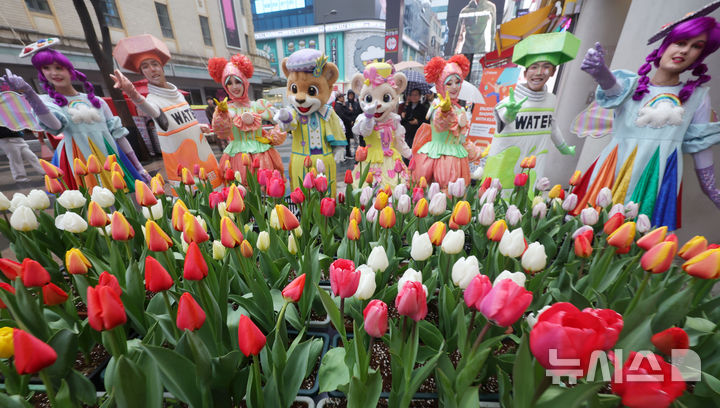 [서울=뉴시스] 홍효식 기자 = 18일 서울 중구 명동 일대 한 거리에서 열린 '도심에서 미리 만나는 에버랜드 튤립축제'에서 에버랜드 공연 연기자들이 포즈를 취하고 있다.에버랜드는 오는 20일부터 '에버랜드 튤립축제'를 개최하며 튤립, 수선화, 무스카리 등 100여종 약 120만송이 형형색색 봄꽃을 선보인다. 2026.03.18. yesphoto@newsis.com