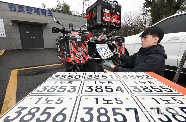 [수원=뉴시스] 김종택 기자 = 이륜자동차 전국 번호판 제도 시행을 이틀 앞둔 18일 경기 수원시 권선구 수원시번호판제작소에서 관계자가 새롭게 도입된 이륜차 번호판을 시연하고 있다.이번에 도입된 이륜차 번호판 규격은 기존 210㎜115㎜에서 210㎜150㎜로 확대됐다. 글자 색상도 파란색에서 검은색으로 변경, 반사 성능이 강화된 재질이 적용돼 주·야간 식별성이 개선됐다. 2026.03.18. jtk@newsis.com