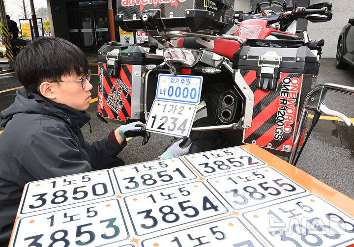 [수원=뉴시스] 김종택 기자 = 이륜자동차 전국 번호판 제도 시행을 이틀 앞둔 18일 경기 수원시 권선구 수원시번호판제작소에서 관계자가 새롭게 도입된 이륜차 번호판(사진 아래)을 시연하고 있다.이번에 도입된 이륜차 번호판 규격은 기존 210㎜115㎜에서 210㎜150㎜로 확대됐다. 글자 색상도 파란색에서 검은색으로 변경, 반사 성능이 강화된 재질이 적용돼 주·야간 식별성이 개선됐다. 2026.03.18. jtk@newsis.com