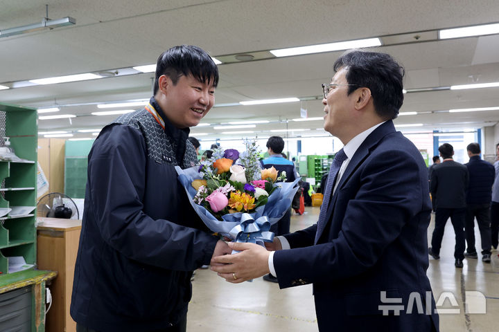 [서울=뉴시스]박인환 우정사업본부장(오른쪽)이 지난 18일 서울강남우체국을 방문해 우편물 배달 중 교통사고로 의식을 잃은 시민을 구하고 교통정리까지 도운 유상범 집배원을 만나 격려하고 있다. (사진=우본 제공)