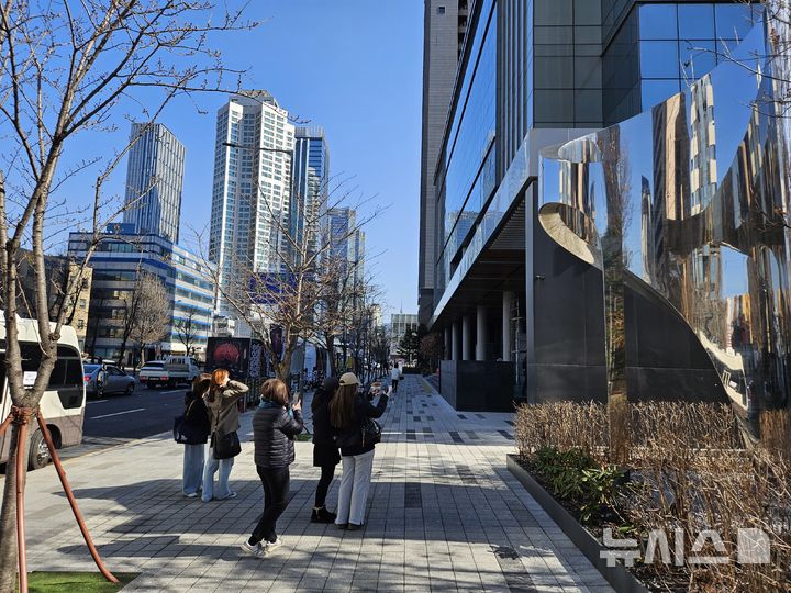 [서울=뉴시스]19일 오전 서울 용산구 하이브 사옥을 찾은 외국인 관광객들이 사진을 촬영하고 있다. 2026.03.19 victory@newsis.com