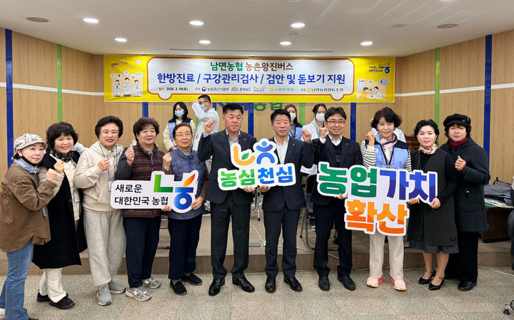 [홍성=뉴시스] 충남세종농협 주관으로 19일 태안군 남면농협에서 농업인 300여명을 대상으로 구강검진, 검안 및 돋보기 지원 등 ‘농촌왕진버스’사업을 첫 실시한 가운데 참가자들이 기념촬영을 하고 있다. (사진=충남세종농협 제공) 2026.03.19 photo@newsis.com *재판매 및 DB 금지