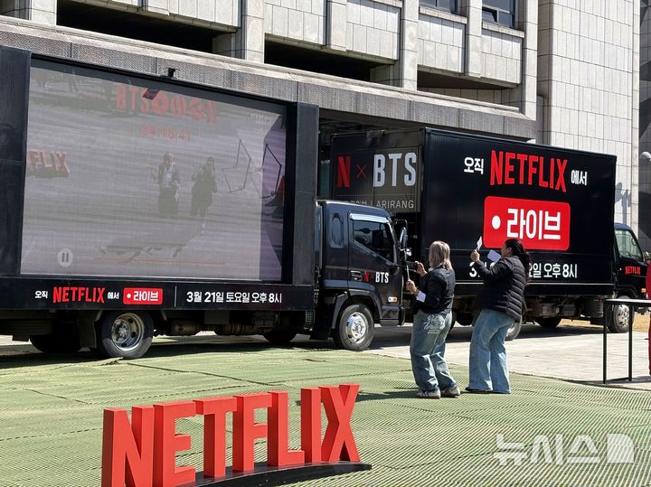 [서울=뉴시스] 한이재 기자 = 지난달 오후 방탄소년단 복귀 공연 안내 차량 앞에서 외국인들이 춤을 추고 있다. 넷플릭스가 1분기 시장 예상을 웃도는 실적을 발표했으나, 창업주 퇴임 소식에 시간외 거래에서 주가는 9%대 하락했다. 2026.04.17. nowone@newsis.com