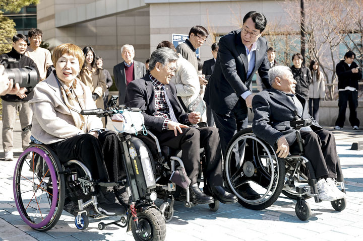 [화성=뉴시스] 정명근 경기 화성시장이 19일 화성시청에서 열린 기아PV5 시승행사에서 휠체어 이동을 돕고 있다.(사진=화성시 제공) 2026.03.19.photo@newsis.com *재판매 및 DB 금지