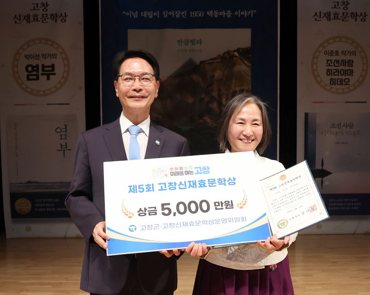 [고창=뉴시스] 지난 18일 고창 동리국악당에서 열린 제5회 고창신재효문학상 시상식, 올해의 문학상 수상작인 '만금빌라'의 저자 이강원 작가(오른쪽)가 상을 받은 뒤 심덕섭 군수(왼쪽)와 사진을 찍고 있다. *재판매 및 DB 금지