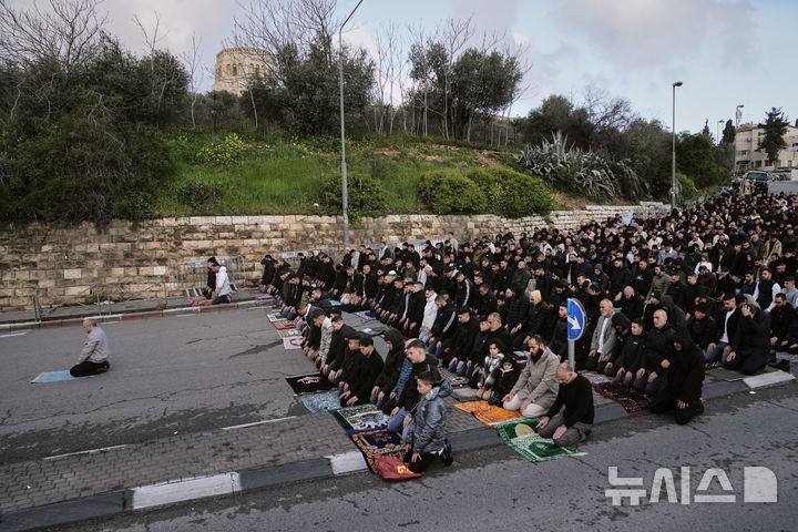 [AP/뉴시스] 라마단 종료로 시작된 이슬람 에이드 알피트르 축일 첫날인 20일 이스라엘 당국의 동예루살렘 구시가지 봉쇄 지속으로 알아크사 모스크에 들어가지 못한 무슬림들이 인근 길바닥에서 예배 기도를 하고 있다&nbsp; 