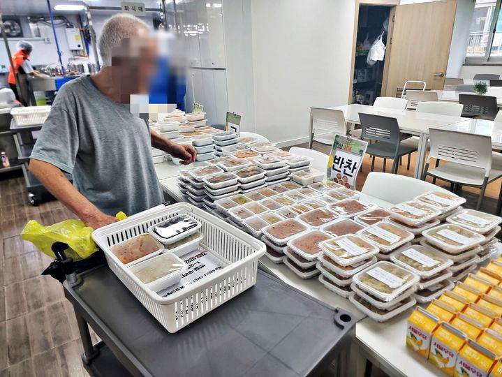 [수원=뉴시스] 학교급식 잔식을 소분한 반찬이 진열된 가운데 한 시민이 필요한 음식을 선택해 가져가고 있다. (사진=수원시 제공) 2026.03.20. photo@newsis.com *재판매 및 DB 금지