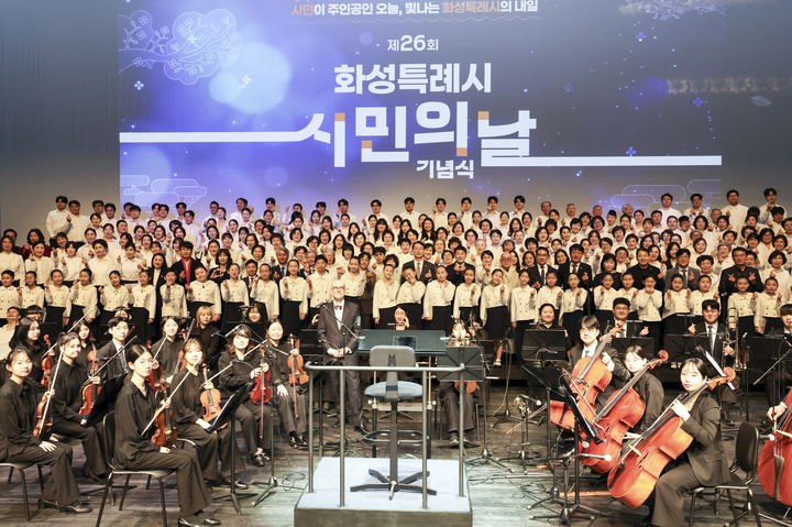 [화성=뉴시스] 20일 화성예술의전당에서 열린 '제26회 화성특례시민의 날' 기념식 무대에서 오케스트라와 연합합창단이 합동 공연한 후 기념촬영을 하고 있다.(사진=화성시 제공) 2026.03.20. photo@newsis.com *재판매 및 DB 금지