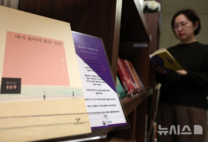 [서울=뉴시스] 이영환 기자 = 방탄소년단(BTS)이 완전체로 컴백하는 20일 오전 서울 서초구 국립중앙도서관 지식의 길에 마련된 BTS의 책장에서 한 시민이 BTS 멤버의 추천 도서를 살펴보고 있다. 방탄소년단은 이날 오후 1시 정규 5집 '아리랑'을 발매하며 국립중앙도서관 지식의 길에 마련된 BTS의 책장은 내달 12일까지 열린다. 전시 도서에는 한강의 '소년이 온다', 이민진의 '파친코', 손원평의 '아몬드', 김애란의 '비행운' 등의 소설이 배치된다. 또 윤동주의 '하늘과 별과 바람과 시' 초판본, 백석의 '사슴' 초판본, 나태주의 '꽃을 보듯 너를 본다' 등 시도 함께 전시된다. 2026.03.20. 20hwan@newsis.com