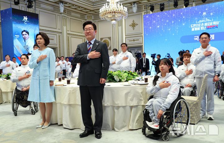 [서울=뉴시스] 최동준 기자 = 이재명 대통령과 김혜경 여사가 20일 청와대 영빈관에서 열린 밀라노-코르티나 동계 패럴림픽 선수단 격려 오찬에서 국민의례를 하고 있다. 2026.03.20. photocdj@newsis.com