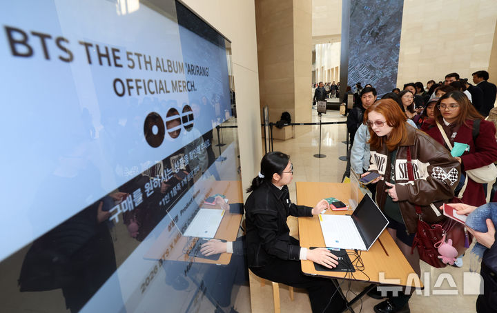 [서울=뉴시스] 배훈식 기자 = 국립박물관재단과 하이브가 협업한 성덕대왕신종 문양을 활용한 '뮷즈' 판매가 시작된 20일 오후 서울 용산구 국립중앙박물관에서 해외 아미(BTS 팬)들이 굿즈 구입을 위해 길게 줄을 서고 있다. 2026.03.20. dahora83@newsis.com