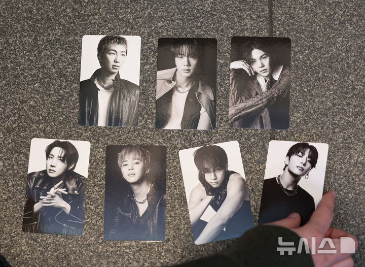 [서울=뉴시스] 권창회 기자 = 방탄소년단(BTS) 컴백 공연을 하루 앞둔 지난 20일 서울 중구 신세계백화점 본점 내 BTS 컴백 팝업스토어에서 팬들이 앨범을 구매한 뒤 포토카드를 진열하고 있다. (사진은 기사와 직접 관련이 없습니다.) 2026.03.29. kch0523@newsis.com