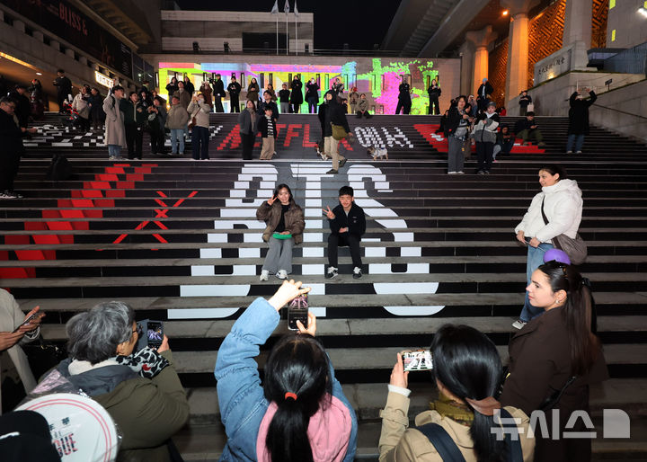 [서울=뉴시스] 배훈식 기자 = BTS(방탄소년단) 완전체 컴백 광화문 공연을 하루 앞둔 20일 오후 서울 종로구 세종문화회관 계단에서 공연을 기다리는 아미들이 기념사진을 찍고 있다. 2026.03.20. dahora83@newsis.com