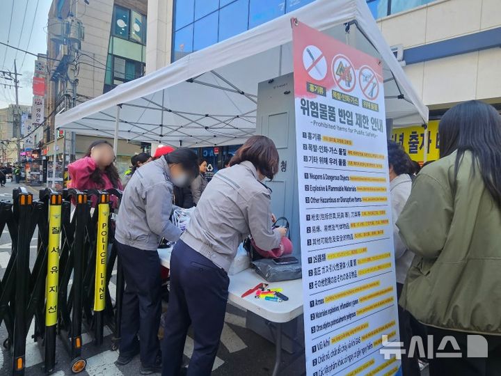 [서울=뉴시스] 조성하 기자=21일 서울 종로구 광화문광장 인근에서 방탄소년단(BTS) 공연을 앞두고 설치된 검색대에서 경찰이 관람객을 대상으로 소지품 검사를 실시하고 있다. 현장에는 천막 형태의 임시 게이트가 설치돼 금속탐지기와 함께 출입 통제가 이뤄지고 있다. 2026.03.21. create@newsis.com