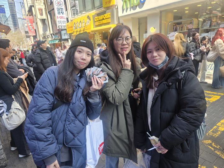 [서울=뉴시스] 강은정 기자= 21일 서울 중구 명동 A굿즈샵 앞에서 왼쪽부터 대만에서 온 멍제이(22)·조앤(29)·비키(26)씨가 방탄소년단(BTS) 포토카드를 들고 있다. 2026.03.21. eunduck@newsis.com *재판매 및 DB 금지