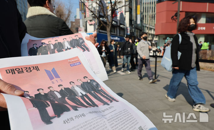 [서울=뉴시스] 권창회 기자 = 방탄소년단(BTS) 컴백 공연 당일인 21일 서울 종로구 광화문광장에서 주요 일간지들이 발행한 BTS 관련 호외를 관계자가 배포하고 있다. 2026.03.21. kch0523@newsis.com
