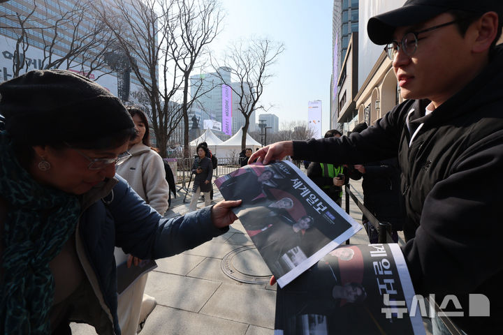 [서울=뉴시스] 권창회 기자 = 방탄소년단(BTS) 컴백 공연 당일인 21일 서울 종로구 광화문광장에서 주요 일간지들이 발행한 BTS 관련 호외를 관계자가 배포하고 있다. 2026.03.21. kch0523@newsis.com