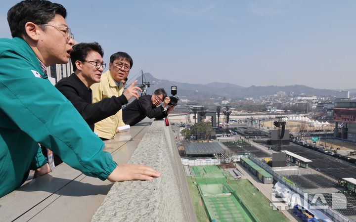 [서울=뉴시스] 청사사진기자단 = 김민석 국무총리가 21일 오전 서울 종로구 세종문화회관 옥상에서 BTS 컴백공연 무대가 설치된 광화문광장을 살펴보고 있다. 2026.03.21. photo@newsis.com