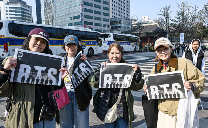 [서울=뉴시스] 그룹 방탄소년단(BTS) 컴백 공연을 앞둔 21일 서울 광화문 일대에서 일본인 관광객들이 한국일보가 발행한 BTS 특별판을 들어 보이고 있다. (사진=한국일보 제공) 2026.03.21. photo@newsis.com *재판매 및 DB 금지