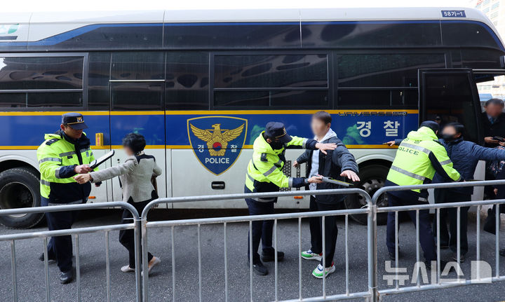 [서울=뉴시스] 조성우 기자 = 그룹 방탄소년단(BTS) 컴백 공연이 열리는 21일 오후 서울 중구 서울광장 인근에서 공연장 주변 결혼식 하객들이 경찰 기동대 버스에서 내려 핸드스캐너 검사를 받고 있다. 서울경찰청은 이날 오후 3시부터 4시까지 을지로3가역~한국프레스센터 구간에 기동대 버스를 투입해 하객 이동을 지원한다고 밝혔다. 2026.03.21. xconfind@newsis.com
