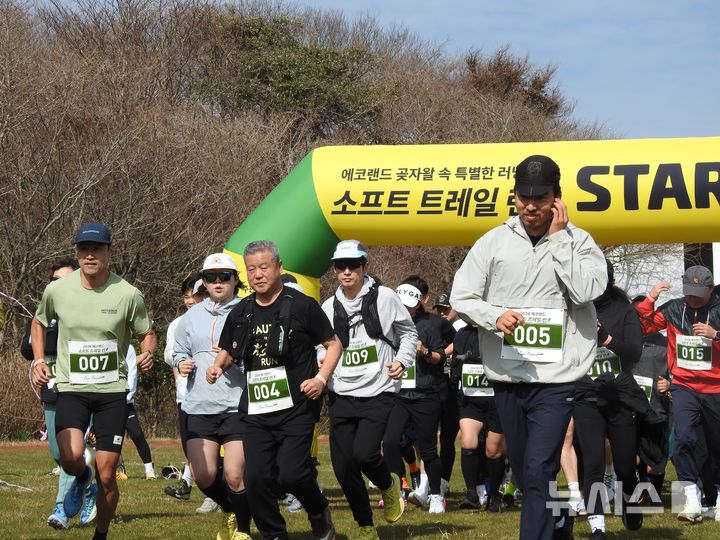 [제주=뉴시스] 김수환 기자 = 22일 오전 제주시 조천읍 에코랜드에서 열린 소프트 트레일 런 행사 참가자들이 대회 시작 신호에 맞춰 아치를 통과하고 있다. 2026.03.22. notedsh@newsis.com