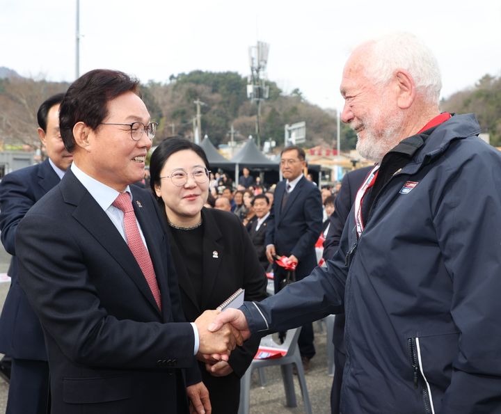 [통영=뉴시스][통영=뉴시스] 신정철 기자= 경남통영호를 비롯 ‘2025-26 클리퍼 세계일주 요트대회’ 참가 요트 10척과 26개국 200여 명의 선수단들이 22일 오후 1시 30분, 경남도민의 열렬한 환송을 뒤로하고 요트 퍼레이드를 펼치면서 경남 통영항을 출항했다. 사진은 박완수 경남지사가 영국 클리퍼벤처스 공동회장인 로빈 녹스-존스턴 경과 함께 출항식에 참석해 인사하고 있다.(사진=경남도 제공).2026.03.22. photo@newsis.com *재판매 및 DB 금지