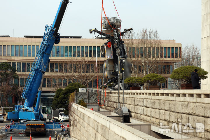 [서울=뉴시스] 고승민 기자 = 22일 서울 여의도 국회 본청에서 대형 크레인에 의해 옮겨지던 소형 크레인 차량에 사고가 발생, 차량이 줄에 그대로 매달려 있다. 2026.03.18. kkssmm99@newsis.com