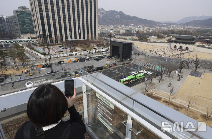 [서울=뉴시스] 김근수 기자 = 22일 오전 서울 종로구 광화문광장에서 전날 열린 방탄소년단의 'BTS 컴백 라이브 : 아리랑' 공연 무대 철거작업이 진행되는 가운데 외국인 관광객들이 사진을 찍고 있다. 2026.03.22. ks@newsis.com