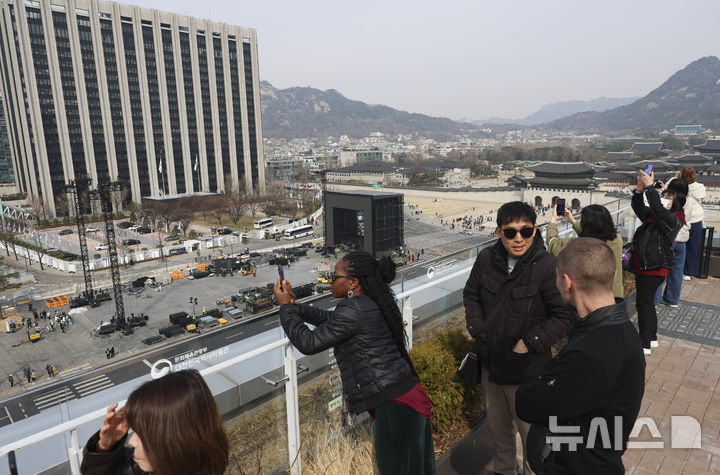 [서울=뉴시스] 김근수 기자 = 22일 오전 서울 종로구 광화문광장에서 전날 열린 방탄소년단의 'BTS 컴백 라이브 : 아리랑' 공연 무대 철거작업이 진행되는 가운데 외국인 관광객들이 사진을 찍고 있다. 2026.03.22. ks@newsis.com