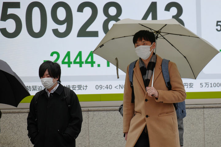 [도쿄=AP/뉴시스]23일 도쿄의 한 증권사 전광판 앞으로 시민들이 걸어가고 있다. 2026.03.23.