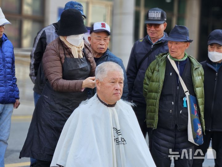 [청주=뉴시스] 연현철 기자 = 일하는 밥퍼 사업 참여자 등 김영환 충북지사 지지자들이 23일 충북도청 서문 앞에서 국민의힘의 김 지사 공천 배제에 항의하며 삭발하고 있다. 2026.03.23. yeon0829@newsis.com