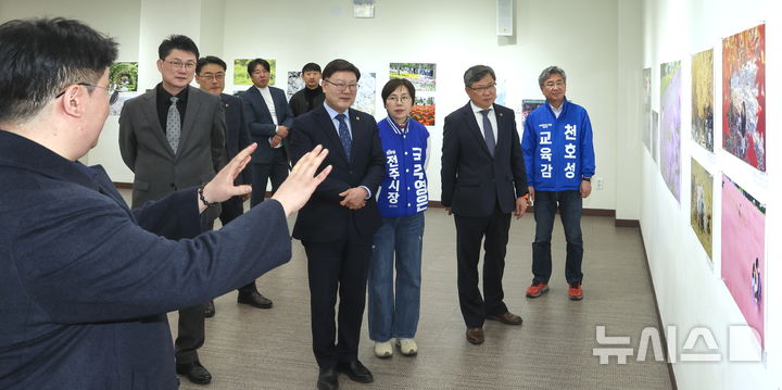 [전주=뉴시스] 김얼 기자 = 김얼(왼쪽) 전북사진기자협회 협회장이 23일 전북 전주시 전북대학교 JBNU컨벤션센터 전시실에서 열린 '2026 전북보도사진전'에서 내빈들과 함께 전시 라운딩을 하고 있다. (사진=전북사진기자협회) 2026.03.23. pmkeul@newsis.com