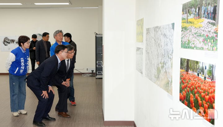 [전주=뉴시스] 김얼 기자 = 문승우(가운데) 전북특별자치도의회 의장과 유정기(가운데 오른쪽) 전북특별자치도교육감 권한대행을 비롯한 관계자들이 23일 전북 전주시 전북대학교 JBNU컨벤션센터 전시실에서 열린 '전북보도사진전'에 참석해 전시를 관람하고 있다. (사진=전북사진기자협회) 2026.03.23. pmkeul@newsis.com