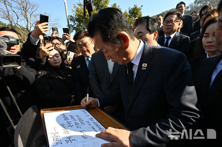 [김해=뉴시스] 차용현 기자 = 23일 오전 더불어민주당 정청래 대표가 경남 김해시 봉하마을 고 노무현 전 대통령 묘역을 찾아 참배를 마친 후 방명록을 작성하고 있다. 2026.03.23. con@newsis.com