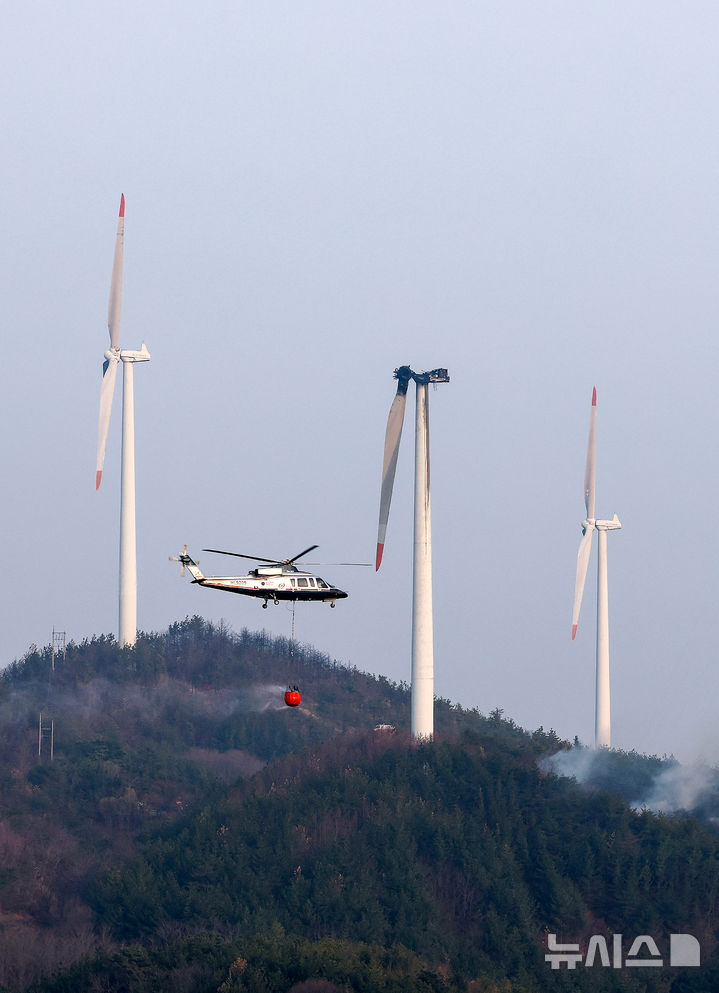 [영덕=뉴시스] 이무열 기자 = 23일 오후 1시 11분께 경북 영덕군 한 풍력발전단지 내 풍력발전기에서 화재가 발생해 출동한 헬기가 발전기와 주변으로 번진 불길을 진압하기 위해 물을 뿌리고 있다.&nbsp; 이 사고로 정비 작업자 3명이 숨졌다. 2026.03.23. lmy@newsis.com