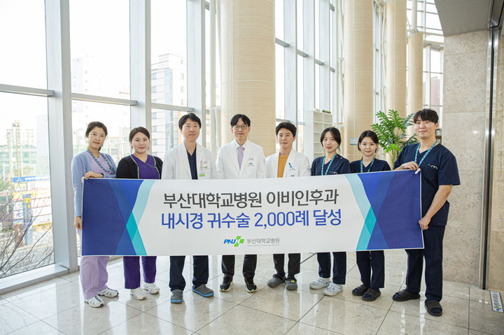 [부산=뉴시스] 최성원(왼쪽 네번째) 교수와 오세준(왼쪽 네번째) 교수 등 부산대병원 이비인후과 의료진이 '내시경 귀수술 2,000례 달성'을 기념해 기념 촬영을 하고 있다. (사진=부산대병원 제공) 2026.03.24. photo@newsis.com *재판매 및 DB 금지